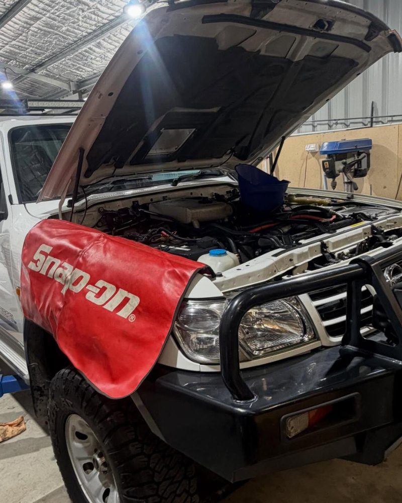 Nissan Patrol with the bonnet up and a Snap-on guard cover in place, mid 4WD service in the MBC workshop, Bendigo.