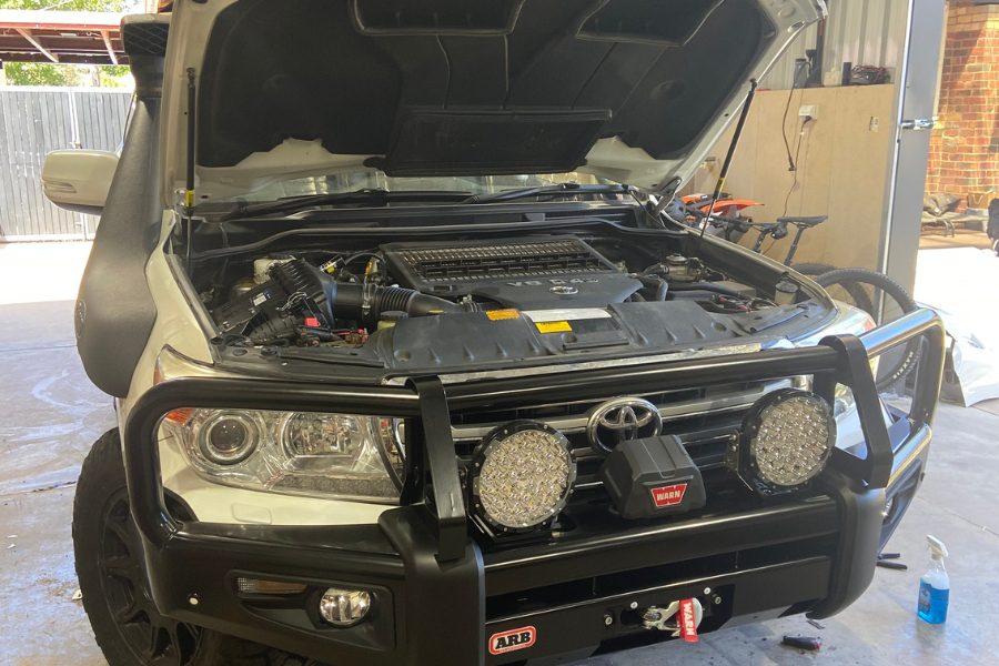 Completed front-end fitout on a 200 Series LandCruiser showing ARB Deluxe Big Tube bull bar, Warn winch, customer supplied 9" round LED driving lights and Safari snorkel at the MBC workshop, Bendigo