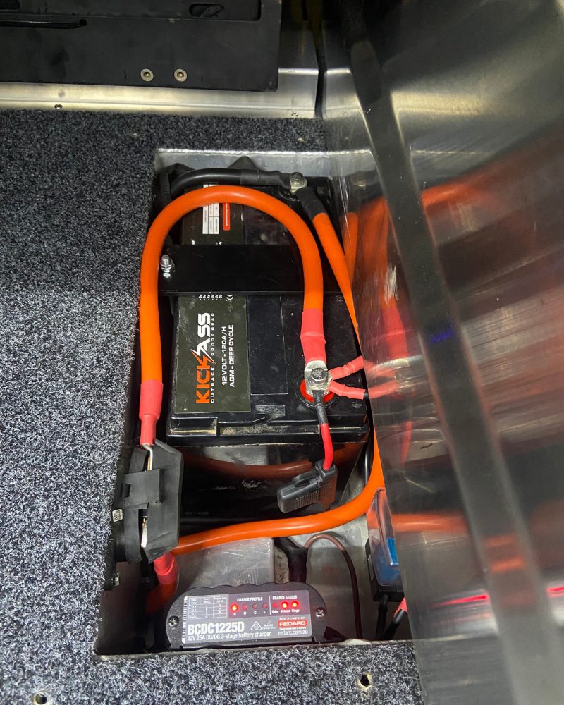 Kickass 120Ah AGM auxiliary battery mounted under the right wing of a rear drawer system in a ute canopy, with a Red Arc BCDC1225D charger, fitted by MBC 4X4 Solutions in Epsom