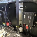 Custom lithium battery fitted behind the rear seat of a Toyota Hilux dual cab for a 4x4 touring build, with a Red Arc Alpha 50B charger, by MBC 4X4 Solutions in Bendigo