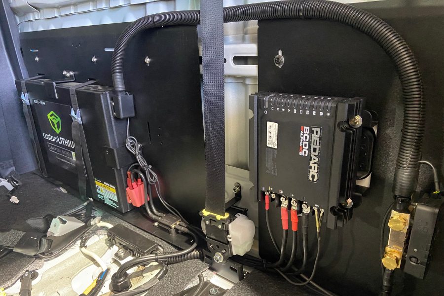 Custom lithium battery fitted behind the rear seat of a Toyota Hilux dual cab for a 4x4 touring build, with a Red Arc Alpha 50B charger, by MBC 4X4 Solutions in Bendigo